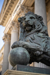 Estatua de un le&oacute;n de cobre sosteniendo una bola
