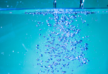 Naklejka na ściany i meble Air bubbles rise in clear water.