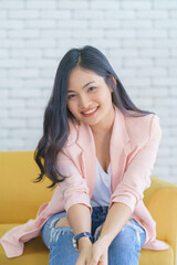 Asian woman smile relaxing sitting on sofa at living room, Lifestyle relax concept.