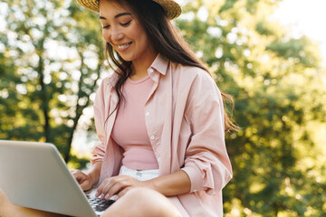 Image of happy asian girl smiling and using mobile phone