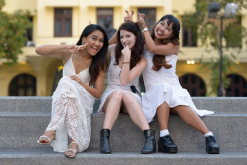 Obraz premium Three multi ethnic young beautiful women as friends together in the park