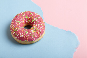 Donut ring on torn pastel paper background.