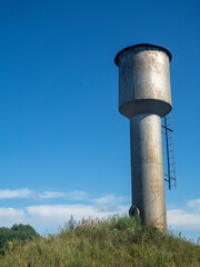 Old metal water tower In Sunny Day In Countryside In Russia In Summer.