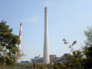 Fototapeta na wymiar Factory chimney, industrial smoke chimneys, Tall industrial factory chimney smokestacks of jute mill industry in Ganges riverside of Kolkata West Bengal India South Asia Pacific