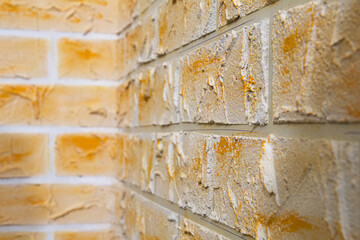 Close up view of corner of wall made of hand made gypsum plaster bricks. Abstract geometric pattern. Light orange background