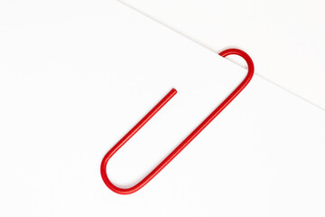 Red paper clip on white paper
