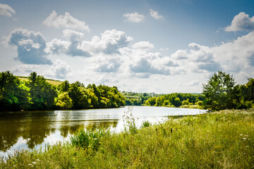 Fototapeta premium Beautiful summer landscape of green nature. Forest, river and hills