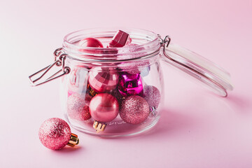 Small pink Christmas balls in a glass jar
