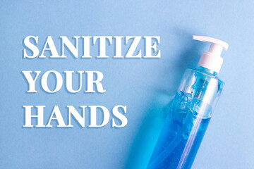 Flat lay bottle of sanitizing gel on blue background, text advise