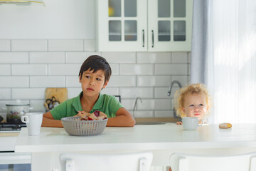 A brother and a sister having their breakfast