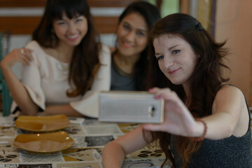 Three young beautiful women as friends together at the coffee shop