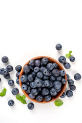 Blueberry fruit top view isolated on a white background, flat lay overhead layout with mint leaf, healthy design concept.