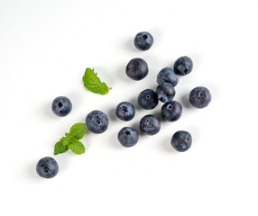 Blueberry fruit top view isolated on a white background, flat lay overhead layout with mint leaf,...