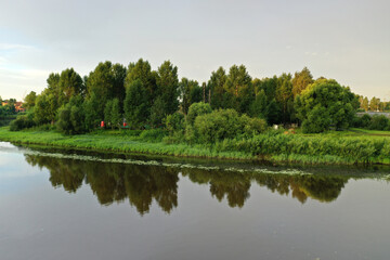 Obraz premium river with reflective trees and clouds at dawn filmed from a dronedefault