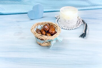 Fototapeta premium The Muslim feast of the holy month of Ramadan . Beautiful background with a shining lantern and dried dates on wooden boards.