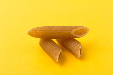 Pasta from hard wheat. Italian pasta on yellow background,  place for text.