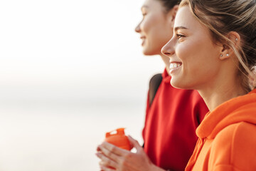 Smiling gorgeous girls friends walking outdoors.
