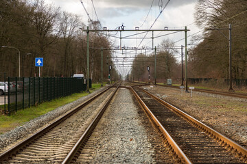 Fototapeta premium Train tracks between trees in wintertime 