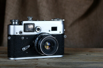 Old film camera. Vintage film photo camera on old wooden background.