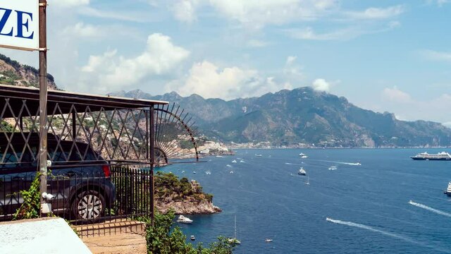 Hiper time lapse view from Conca dei Marini on Amalfi bay, Luxury boats traffic, ocean liner, fishing boats, tourist season. watercraft. Mountains and houses, buildings. Summer. Amalfitana Italy
