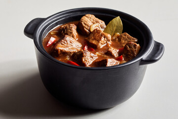 Serving of beef goulash in a cast iron pot