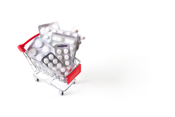 Blister pack tablets in shopping cart on white background with copy space. Online shopping and...