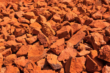 A look at the perspective of a surface covered with pieces of broken red brick. Background. Texture.