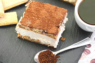 Delicious treat - dessert, creamy tiramisu and coffee on rustic table closeup