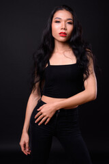 Obraz na płótnie Canvas Young beautiful Asian transgender woman against black background