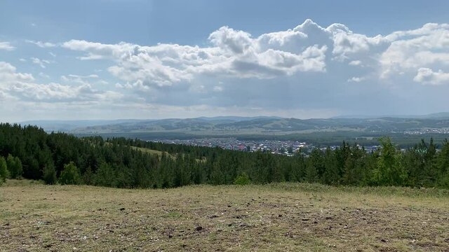 Beautiful panoramic view from the mountain to the summer landscape. Mountains, mountain lake, forests, fields. Top view. Somewhere in Russia.