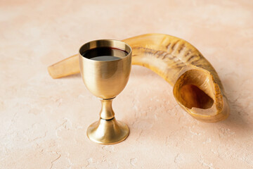 Shofar and sacramental goblet with wine on color background. Rosh Hashanah (Jewish New Year) celebration