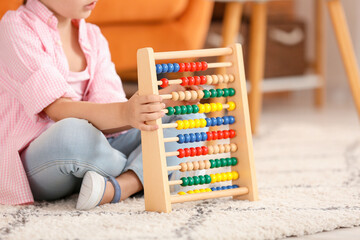 Little girl with autistic disorder playing with abacus at home
