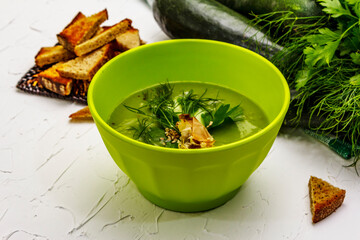 Green zucchini cream soup. Healthy vegan (vegetarian) food, crispy toast, sesame seeds, whole ripe fruits, fresh greens