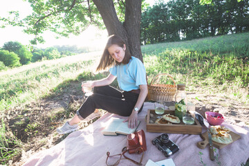 Naklejka na ściany i meble girl on a picnic in a meadow