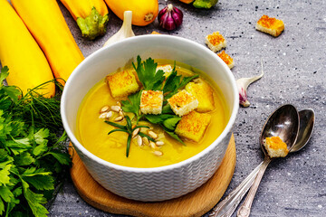 Yellow zucchini cream soup. Healthy vegan (vegetarian) food, crispy toast, sunflower seeds, whole ripe fruits, fresh greens