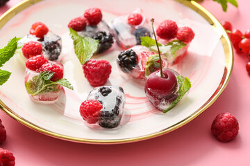 Plate with ice and frozen berries on color background
