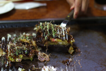 Close up of delicious fried Okonomiyaki (Japanese pancake), Kyoto, Japan, soft focus