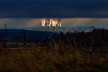 Fototapeta na wymiar Illuminated smoking cooling towers of thermal power station on background in dark.
