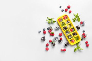 Tray with berries in ice on light background © Pixel-Shot