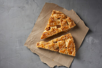 two baked pieces of apple pie on brown paper, top view