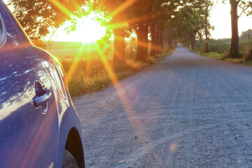 The sun's rays blue cars on the road. The sunset and the car.