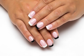 Fototapeta premium French white, black manicure on short square nails close-up on a white background