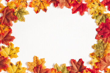 Naklejka na ściany i meble Autumn composition. Frame made of maple leaves on white background. Autumn, fall, thanksgiving day concept. Flat lay, top view, copy space