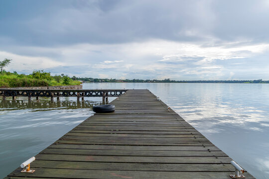 Wooden pier on a lake scene, horizontal view with a beautiful rustic background