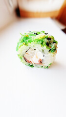 Green sushi roll with sauce, sesame seeds and chukoy salad