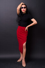 Young beautiful Asian transgender businesswoman against black background