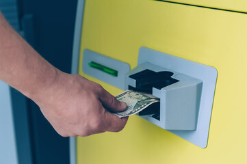 Man takes out dollars from an ATM machine.