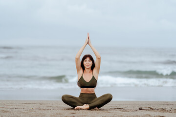 Fototapeta na wymiar woman doing yoga exercises on the beach summer time
