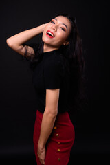 Fototapeta premium Young beautiful Asian transgender businesswoman against black background
