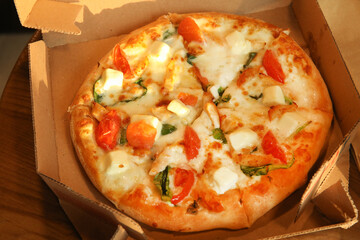 Freshly baked delivery pizza in plain open box